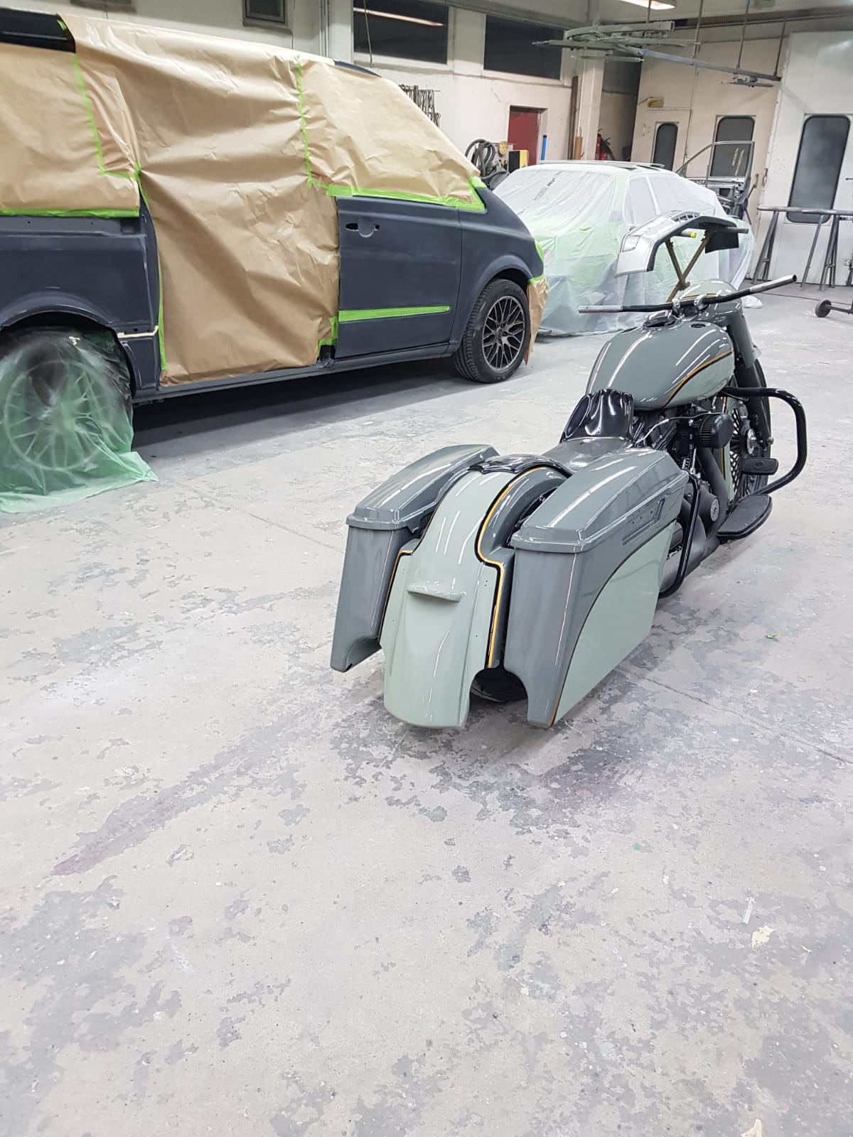 Motorradteile in Grundierung vor der Halle