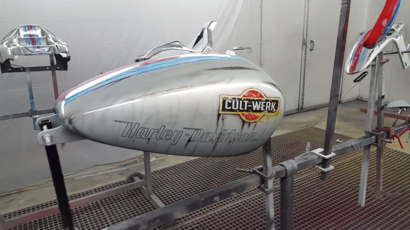 Silberner Motorradtank mit Emblem und Zierstreifen
